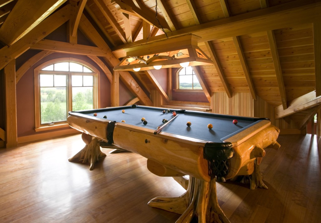 Timber framed games room in Ridgeview home with natural log pool table